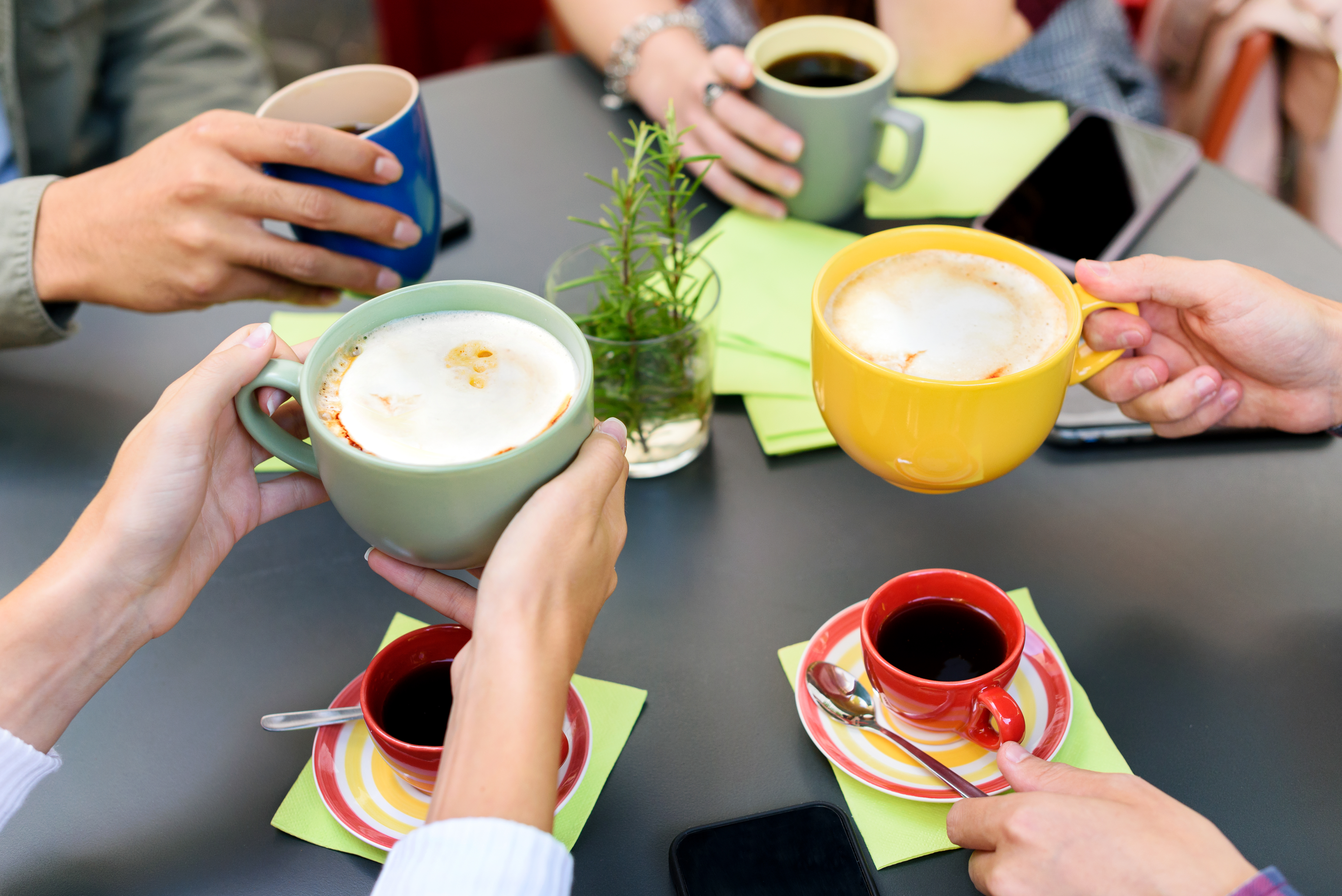 A coffee meeting at a wooden table with beverages